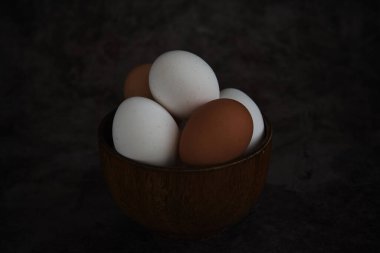 Beyaz ve kahverengi tavuk yumurtaları kasede.