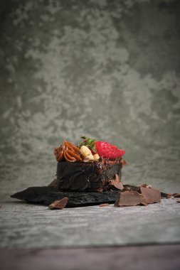 Gri arka planda çilekli çikolatalı pasta.