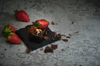 Gri arka planda çilekli çikolatalı pasta.