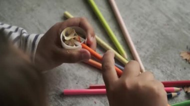 Küçük kız renkli kalemleri açarmış.