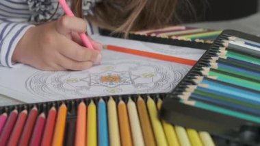 Yakın çekim bebek eli ve renkli kalemler.