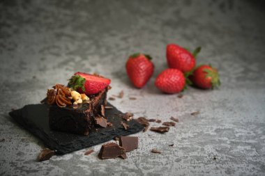 Gri arka planda çilekli çikolatalı pasta.