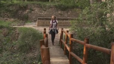 Bir kız tahta bir köprüden geçiyor