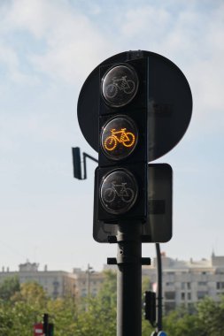 Şehir, gökyüzü ve ağaçların arka planında trafik ışıklarında çalışıyor.