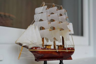 Yelkenli bir deniz gemisinin küçük bir modeli. Beyaz arkaplanda.