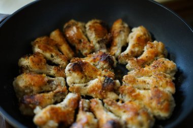 Kızarmış tavuk kanadı. Altın rengi. Bir tavada.
