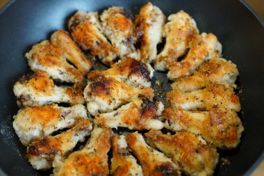 Kızarmış tavuk kanadı. Altın rengi. Bir tavada.