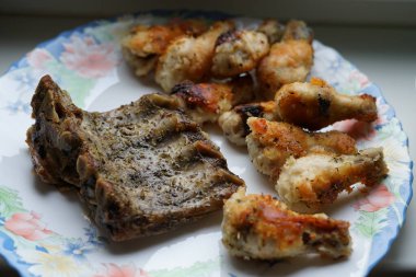 Kızarmış tavuk kanadı ve kızarmış kaburga. Tabakta..