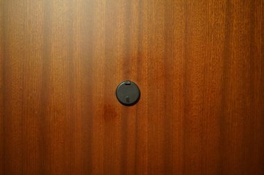 Kapıda kara gözetleme deliği var. Kapı maun renginde..