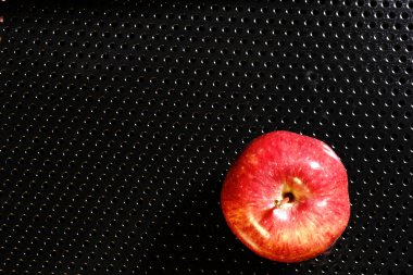 Siyah arka planda kırmızı elma. Yarı ışık ve parlak bir Apple..