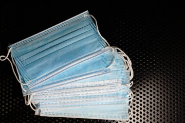 Siyah metal arka planda tıbbi maskeler. Salgına karşı mücadele.