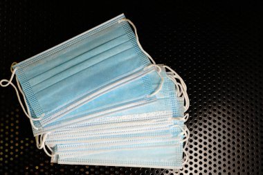 Siyah metal arka planda tıbbi maskeler. Salgına karşı mücadele.