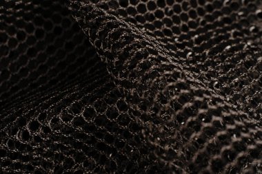 Siyah doku. Siyah bir ağ siyah delikli metal bir masanın üzerine yerleştirilir. Işık parlıyor..