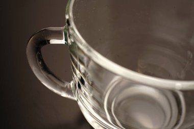 Boş şeffaf çay fincanı. Yukarıdan manzara. Siyah arka planda. Loş ışıklar.