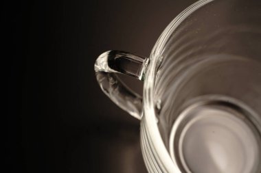 Boş şeffaf çay fincanı. Yukarıdan manzara. Siyah arka planda. Loş ışıklar.