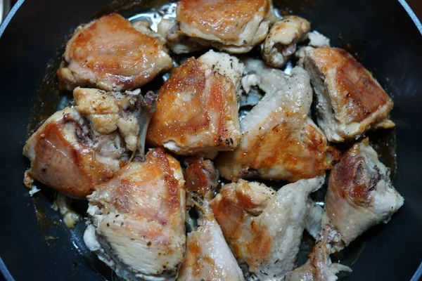 Chicken pieces fried in a frying pan. Only cooked. With a golden crust. — Stock Photo, Image