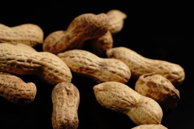 Siyah arka planda bir sürü kabuklu fıstık var. Yakın çekim..