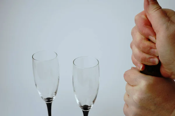 We open a bottle of champagne on a white background with glasses. Hands and a traffic jam are visible.
