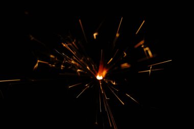 Karanlığın içinde kıvılcımlar. Sarı-kırmızı renk. Yakın çekim..