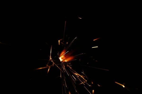 Sparks in total darkness. Yellow-red color. Closeup.