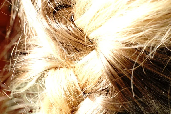 Cabelo loiro das mulheres para trás penteado. Seu cabelo está bem trançado.. — Fotografia de Stock