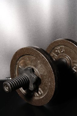 Siyah arka planda siyah bir dambıl. Halter ve krep..