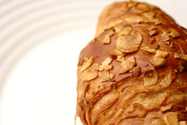 Een broodje gebak op een wit bord. isolaat. — Stockfoto