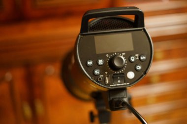 Siyah stüdyo flaşı tripodun üzerinde duruyor ve fotoğraf için hazır..