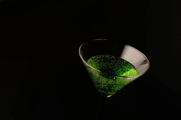 黒を基調としたグリーンのカクテル2杯。一方のガラスは満杯でもう一方は空です — ストック写真