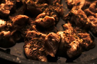 Fırında pişirilmiş domuz eti dilimleri. Kahverengi renk.