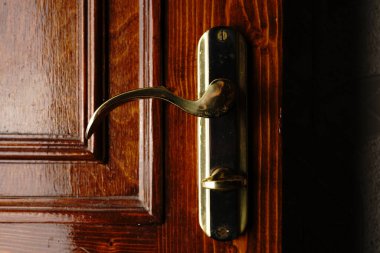 Maun kapısının sapı altın renginde. Sönük ışıklar.