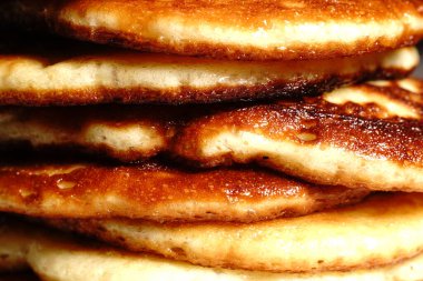 Altın krepler bir tabağın üzerinde, birbiri ardına. Yakın çekim..