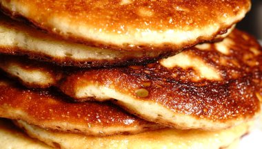 Altın krepler bir tabağın üzerinde, birbiri ardına. Yakın çekim..