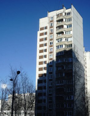 Çok katlı evler ve arka planda açık mavi bir gökyüzü. Şehir manzarası. Yaz