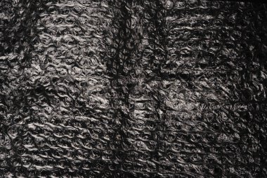 Siyah arkaplan dokusu üzerine baloncuk ambalajı. Sönük ışıklar.