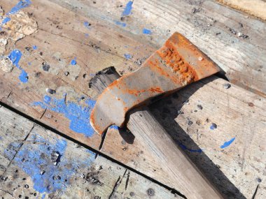 Masanın üzerinde paslı bir balta var. Kılıç açıkça görülüyor.