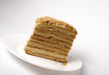 Beyaz tabakta bir sürü katmanı olan ev yapımı ballı kek.