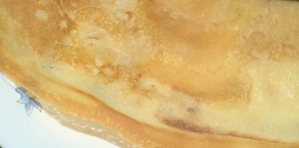 Une fine crêpe est dans l'assiette. Gros plan. Petit déjeuner — Photo