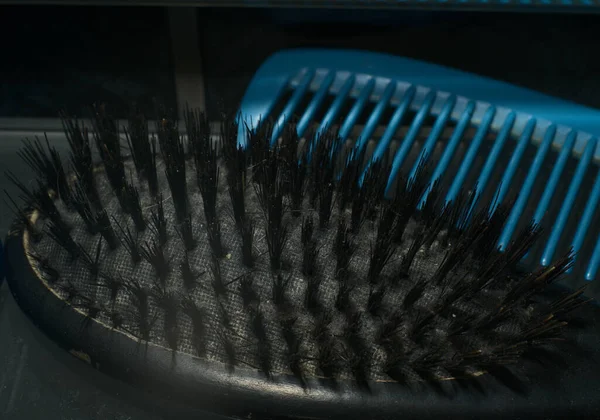 Two hair combs are lying side by side on the shelf. Closeup. Dimmed lights — Stock fotografie