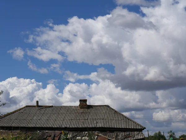 在阳光明媚的夏日，一座古老的木头房子，蓝天，白云密布 — 图库照片
