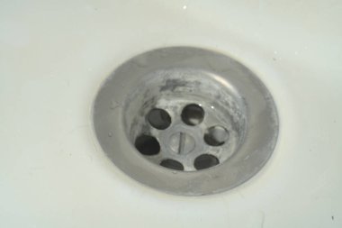 Beyaz lavabo zemininde metal lavabo. Yakın çekim.