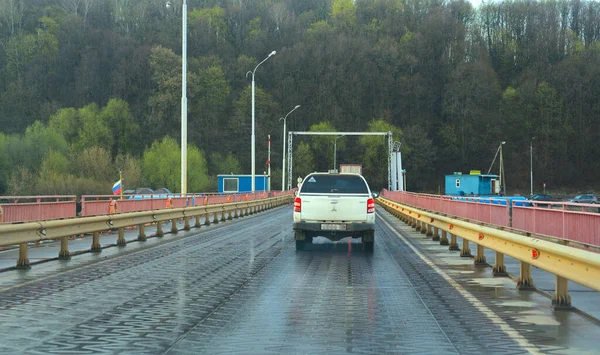 Moskva, Rusko - 11. května 2021: Přes řeku na dočasném mostě projíždí bílé SUV auto. Jarní jasné počasí — Stock fotografie