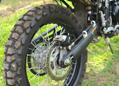 Moskova, Rusya - 14 Mayıs 2021: Arka tekerlek yeni Kawasaki kros motorsikletine şehrin dışındaki yeşil çimlerin arka planına yakın. Bir bahar günü