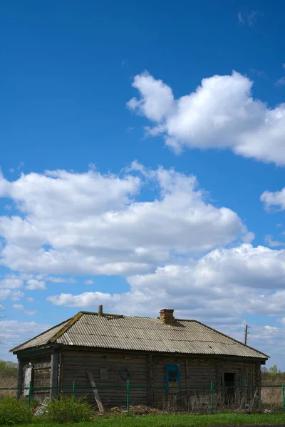 Una vieja choza de madera construida en los años 50 del siglo XX y un cielo azul con nubes blancas. Primavera. Espacio para el texto —  Fotos de Stock