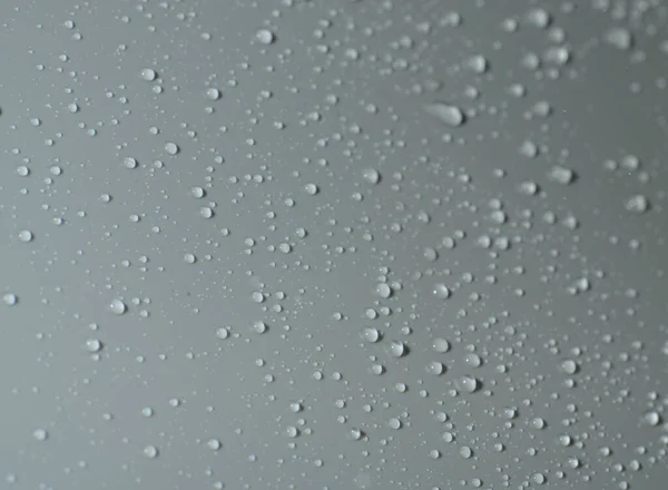 La textura de una gota de agua sobre un fondo gris. Primer plano. —  Fotos de Stock