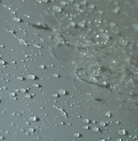 水滴は薄い灰色の背景に落ちる。閉鎖 — ストック写真