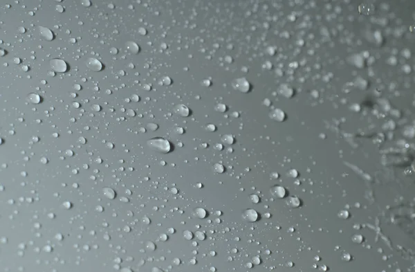 La textura de una gota de agua sobre un fondo gris. Primer plano. Imagen de stock