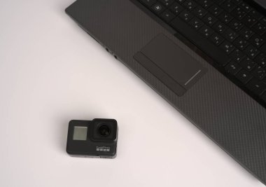 Moskova, Rusya - 30 Mayıs 2021: GoPro kamera ve dizüstü bilgisayar beyaz arka planda. Metin için yer aç. Üst görünüm