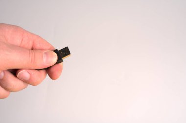 Beyaz arkaplanda siyah usb kablosu olan el.