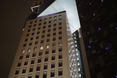 Moskova, Rusya - 15 Şubat 2021: Geceleri cam ve metalden yapılmış, modern tasarımı olan yüksek katlı bina. Alt görünüm